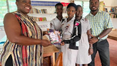 Ekuwah (left) presenting students with her books as Ekow Simpsom (right) looks on